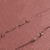 Nærbilde av sprukken, tørr jord- eller leirflate med små sprekker og ujevn tekstur.