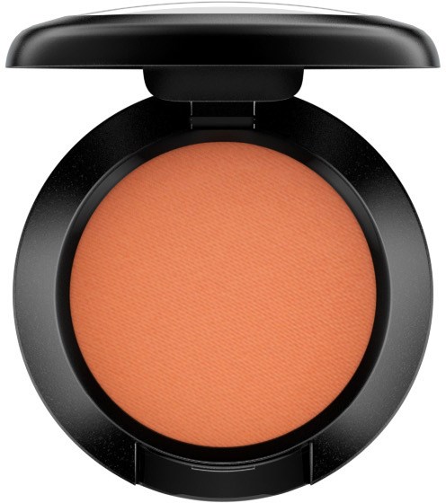 Eine runde Rouge-Compact mit peachfarbener Puder im schwarzen Gehäuse, mit geöffnetem Deckel.