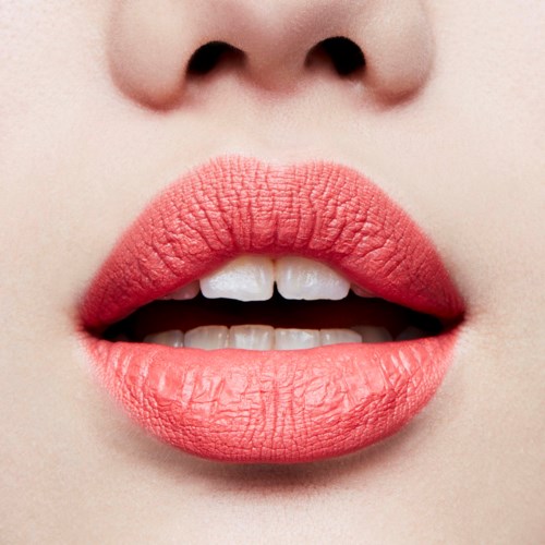 Nahaufnahme von Lippen, leicht geöffnet, zeigt Zähne und glatte Haut, mit mattem rosa Lippenstift.
