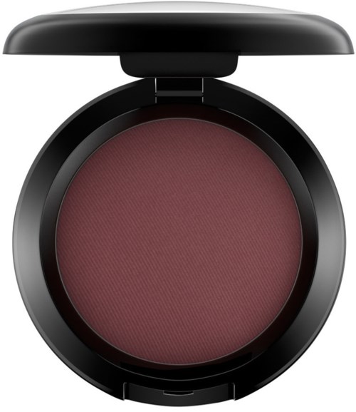 A round makeup blush in a black compact case with a lid open, showing reddish-pink color.