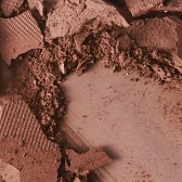 Nahaufnahme eines Make-up-Pinsels, der rosa Make-up auf ein Gesicht aufträgt.