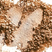 Ett hjärtform är skarvat i sand eller jord, omgiven av små stenar eller korn.