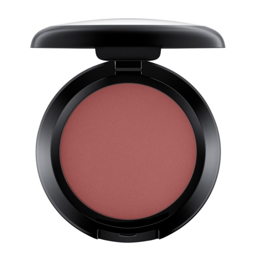 A round blush compact with a black lid open, showing pink powder inside.