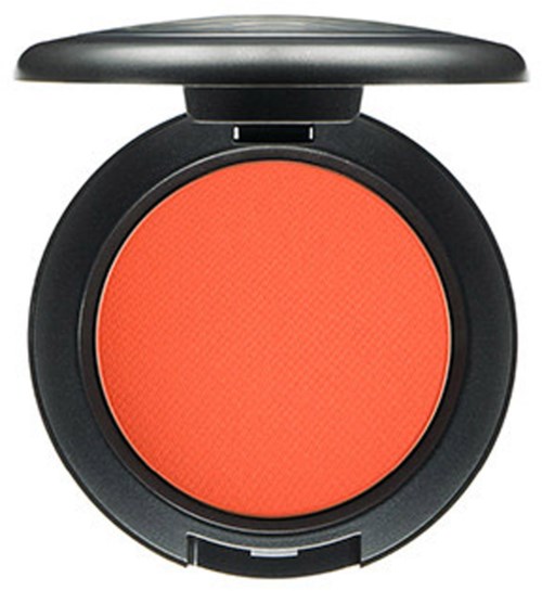 En kompakt rund ansiktsrödgömma med svart case och orange puder inuti.