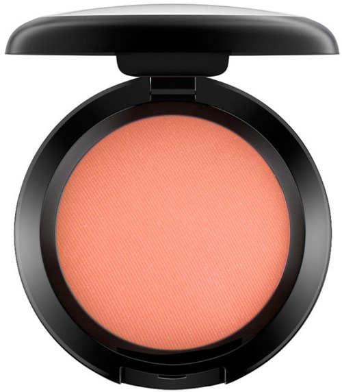 En rund kompakt med peachfärgad rouge inuti, svart lock delvis öppet. Inga andra föremål synliga.