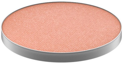 En rund makeup blush i ett silverfodral, persikofärgad med en strukturerad yta.