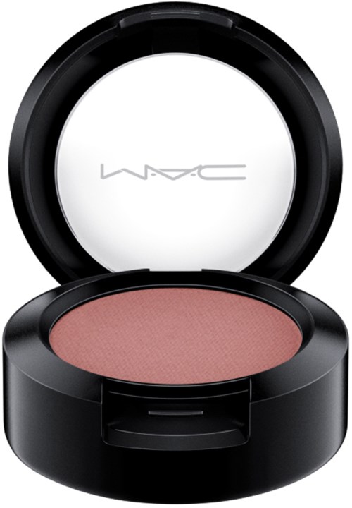 En runt makeuprougekompakt med rosa rouge inuti och ett svart ytterhölje.