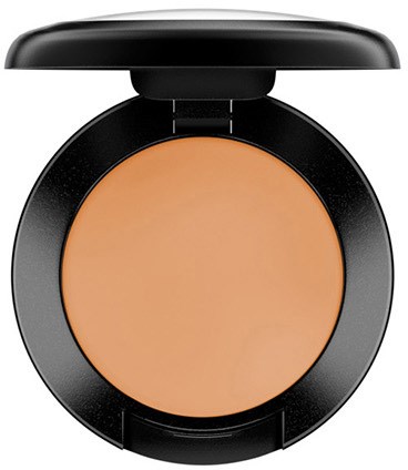 Ein kleiner Make-up-Pulverbehälter mit schwarzem Deckel, geöffnet, zeigt hellbeiges Puder.