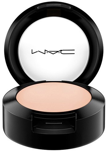 En lille makeupbeholder fra MAC med lys farvet pulver og åben låg.