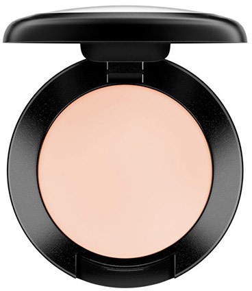 En rund compact med en lys beige pudder og et sort låg, åbent for at vise ansigtspudderet.