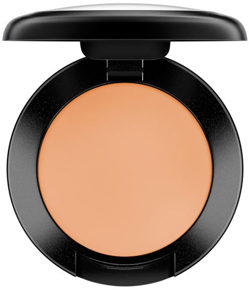 Ein kleiner Make-up-Behälter mit pfirsichfarbenem Puder und schwarzem Deckel.