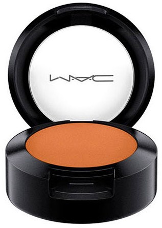 Ein kompakter MAC-Blush in Orange in einer runden schwarzen Dose, die geöffnet wird, um das Produkt zu zeigen.