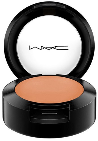 Ein runder schwarzer Makeup-Container mit Spiegel und hellbraunem Puder.