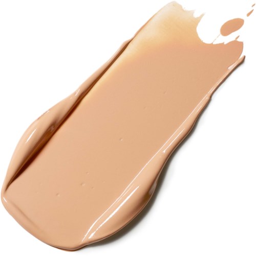 En beige væske spredt på hvid overflade, der ligner makeup eller foundation, med nogle ujævne kanter og en splat.
