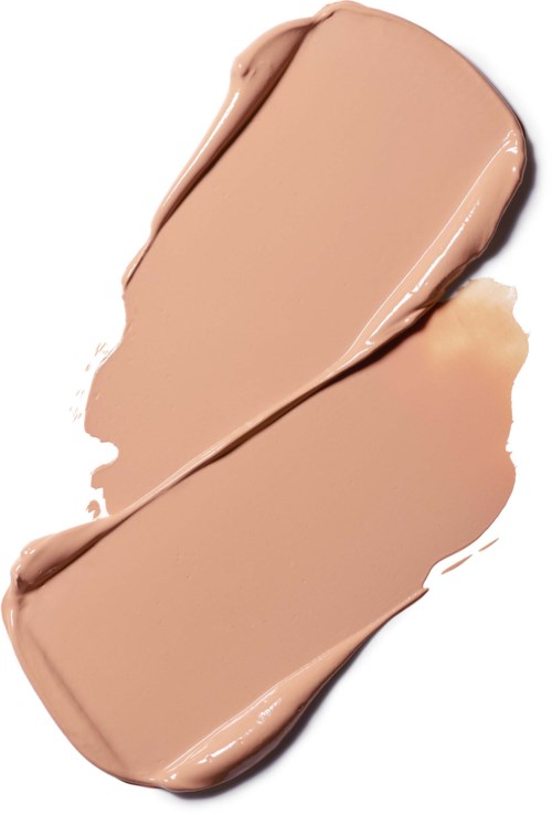 En beige farvet væske spredt på en hvid baggrund, ligner makeup eller foundation. Den er smurt ud og har en glat tekstur.