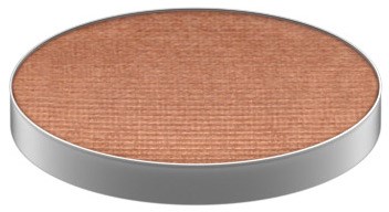 En rund kompakta med beige pudder inni, sølvinnfatning, sannsynligvis sminke eller ansiktspudder.