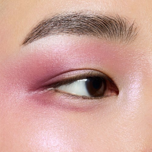 Close-up van een oog met roze oogschaduw en goed gevormde wenkbrauw.