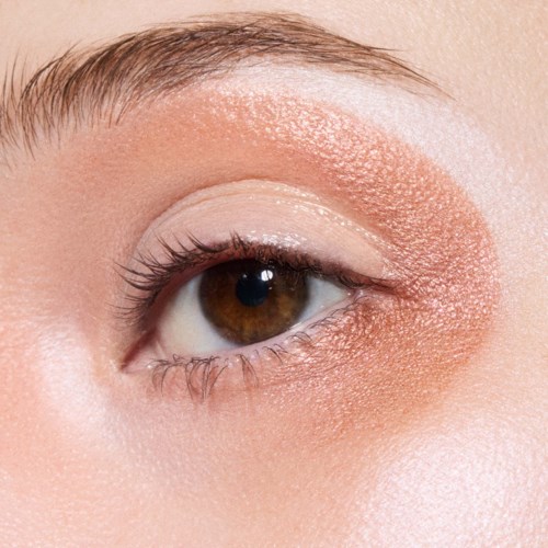 Close-up van iemands oog met make-up, inclusief oogschaduw en mogelijk mascara.
