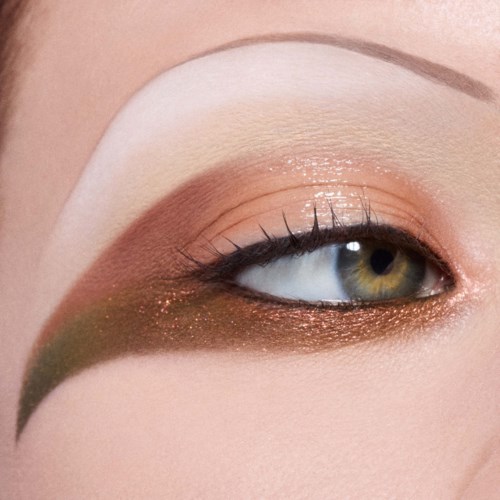Øjen makeup i neutrale toner med glitter, med grøn eyeliner og hvid øjenbrynshøjdepunkter.