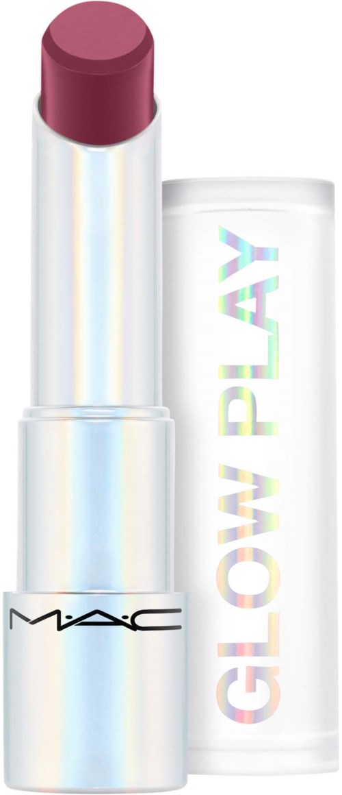 A lipstick with a shiny white case, showing a reddish-brown color. The cap is beside the lipstick, displaying rainbow-colored text.