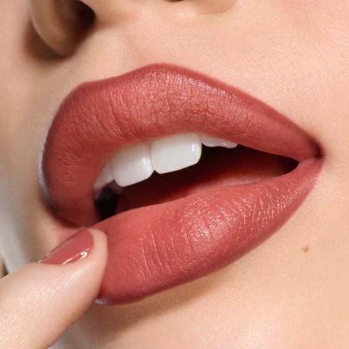 Close-up van lippen met lippenstift, lichtjes open, lachend met tanden zichtbaar, vinger dicht bij lippen.