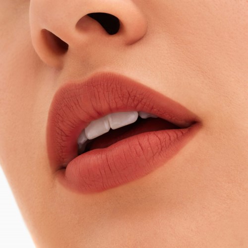 Close-up van iemands lippen die licht open zijn, met tanden zichtbaar, gladde huid eromheen, natuurlijke make-up en gedetailleerde lippen.