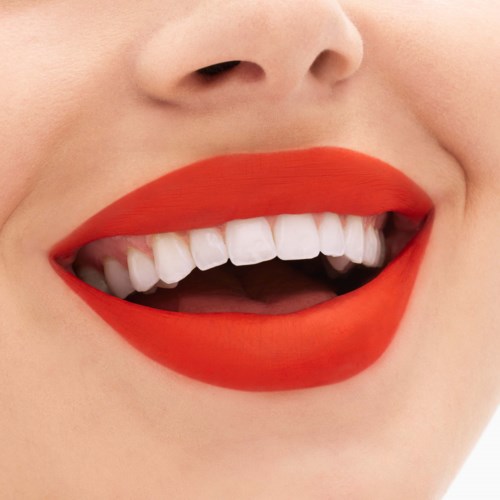 Lachende mond met felrode lipstick en witte tanden. Close-up van lippen en tanden, vrolijke uitdrukking.