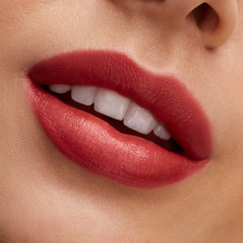 Close-up of a person's mouth showing red lipstick, white teeth, and slightly parted lips.