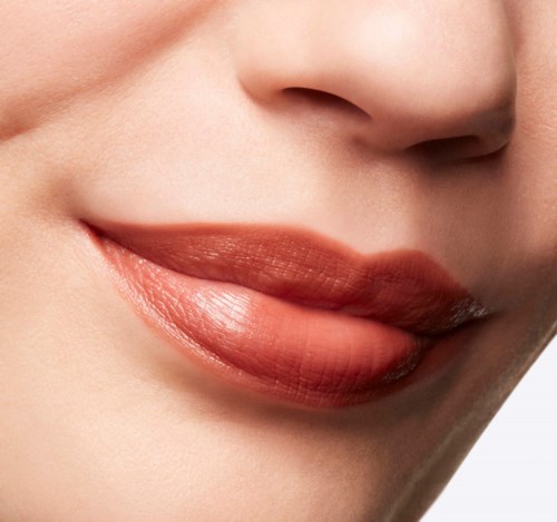 Close-up of lips with glossy lipstick on smooth skin and a slight smile.