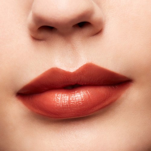 Close-up of lips with pinkish lipstick, part of a person's nose and chin visible.