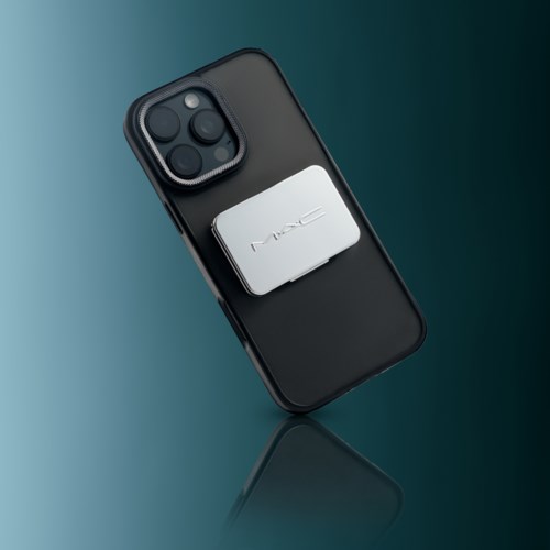 En modern smartphone med en pop socket på baksidan, med en enkel mörk bakgrund.