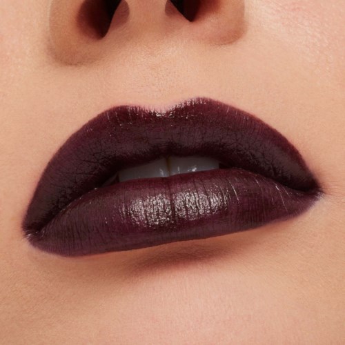 Close-up van lippen met donker glanzend lippenstift, licht gesperd, gladde huid.