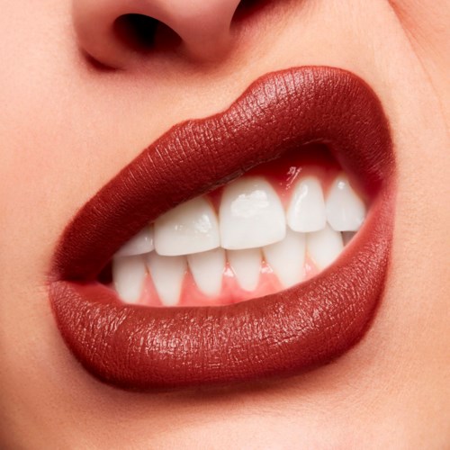 Close-up of a person smiling with red lipstick and visible white teeth.