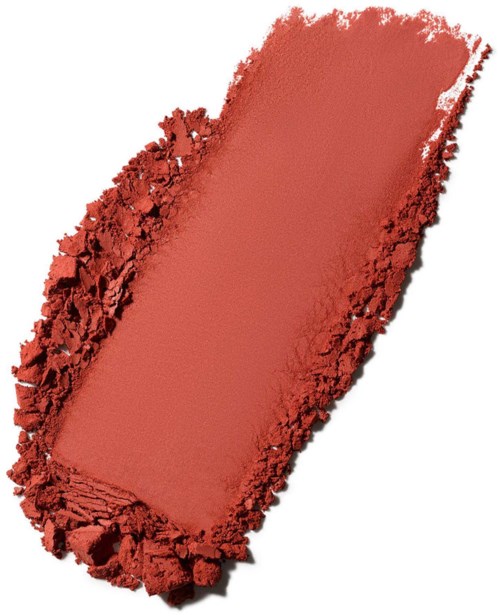 Et rektangulært koralfarvet pudder eller blush omgivet af knust pudder på hvid baggrund.