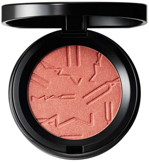 En rund blush med geometriske mønstre indgraveret, i en sort beholder med låg.