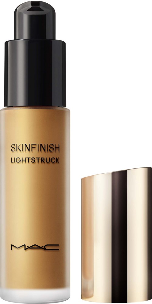 En flaske MAC Skin Finish Lightstuck flydende highlighter med pumpe, guld og sort design, og et guld låg.