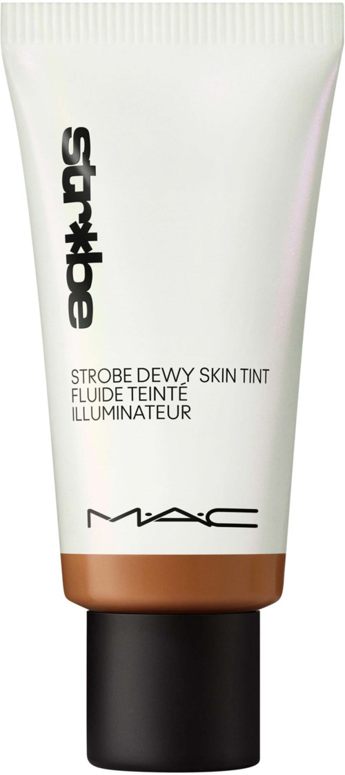 En tub med MAC Strobe Dewy Skin Tint med vit och koppardesign, svart lock och produktnamn skrivet på den.