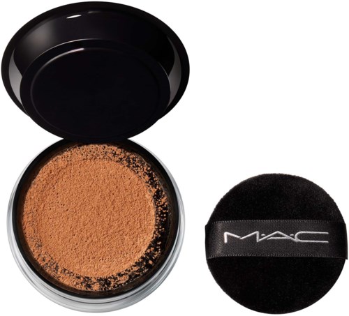 Loses Gesichtspuder in einer schwarzen Dose mit einem Puderpuff daneben. Der Puffer ist schwarz mit MAC-Logo.