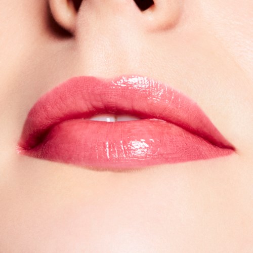 Close-up of lips with pink lipstick, slightly parted, showing a small glimpse of teeth.