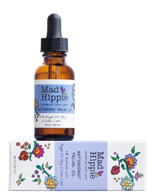 A brown glass bottle with a black dropper cap and a colorful label, next to a tube with floral patterns.