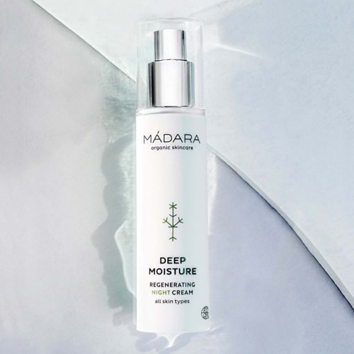 A white bottle with a silver cap labeled 'MADARA' for deep moisture night cream, suitable for all skin types.