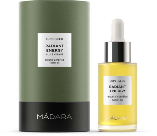 En grønn og svart boks ved siden av en gul ansiktsåpe med pipette, merket 'Radiant Energy' av Madara.