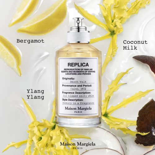 A perfume bottle surrounded by lemon slices, yellow flowers, and coconut milk leaves. The label shows it is from Maison Margiela.