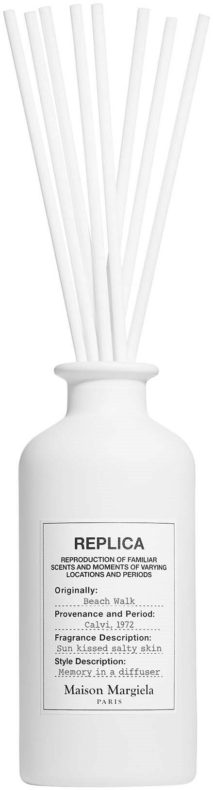 A white bottle with reeds sticking out, labeled 'REPLICA' with details about scent and origin.
