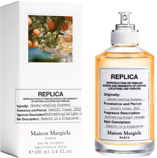 En parfyllflaska märkt "REPLICA" med orange vätska och en vit box med liknande text och en bild av apelsiner och en kust.