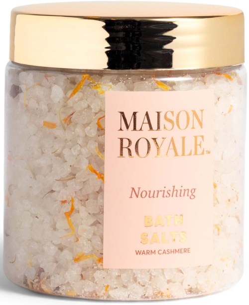 En krukke med nærende badsalt med varm cashmere duft, inneholder hvite og orange saltflak.