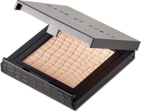 En komp makeup-palett med beige puderhighlighter eller rouge, i ett svart fodral med delvis öppen lock.