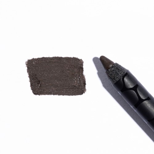 En svart krita med en bruna spets, bredvid en svart smuts på vitt papper.