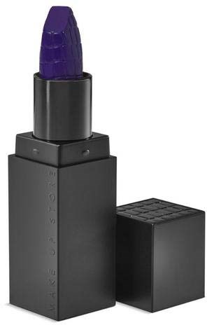 A lipstick in a black case with a purple tip, with the cap removed and placed beside it.