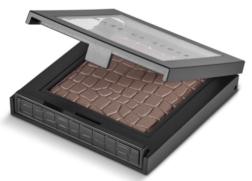 A makeup palette with a variety of brown shades in a black case with a see-through lid.